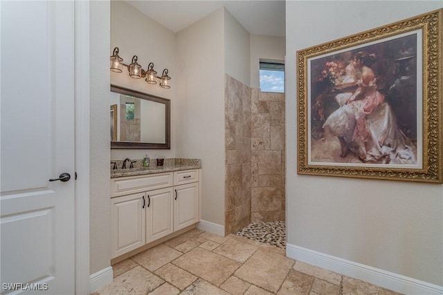 bathroom with tiled shower and vanity