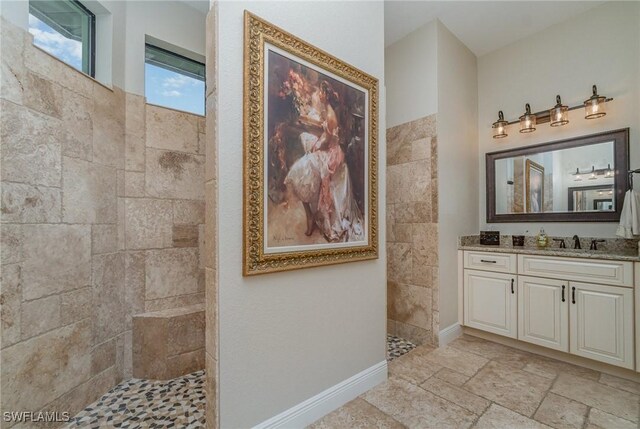 bathroom with vanity and a tile shower