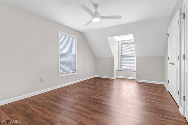 bonus room featuring dark wood-style floors, plenty of natural light, baseboards, and a ceiling fan