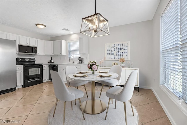 dining room with light tile patterned floors, visible vents, baseboards, a textured ceiling, and a chandelier