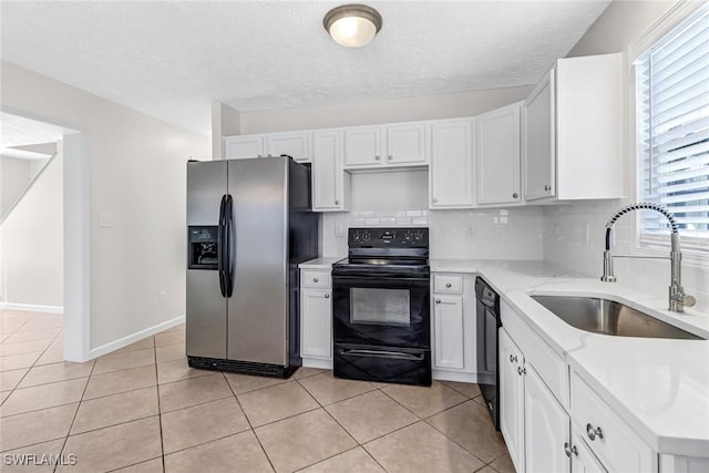 kitchen featuring light tile patterned floors, black appliances, a sink, and decorative backsplash