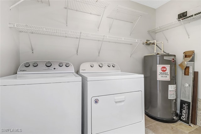 washroom featuring light tile patterned floors, laundry area, washing machine and clothes dryer, and electric water heater