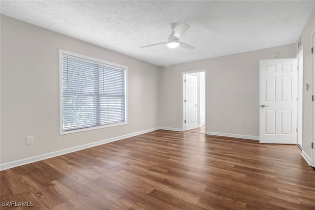 spare room with a textured ceiling, ceiling fan, wood finished floors, and baseboards