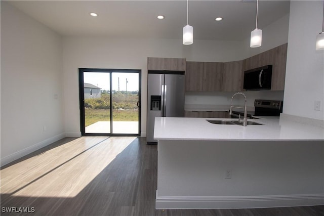 kitchen featuring electric range oven, decorative light fixtures, dark hardwood / wood-style flooring, sink, and stainless steel fridge with ice dispenser