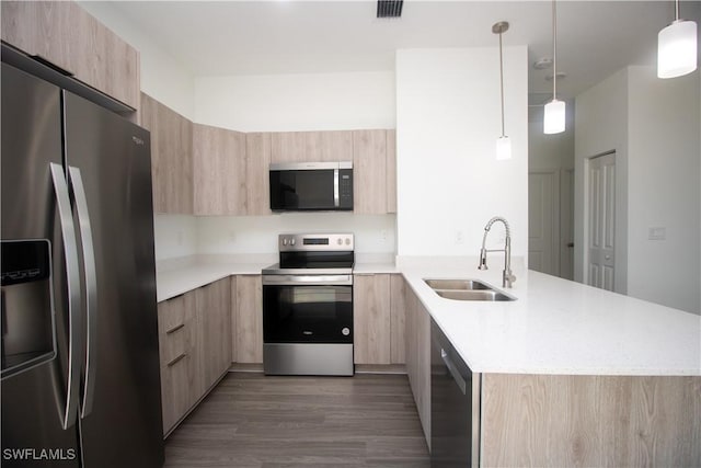 kitchen with decorative light fixtures, light brown cabinetry, appliances with stainless steel finishes, and sink