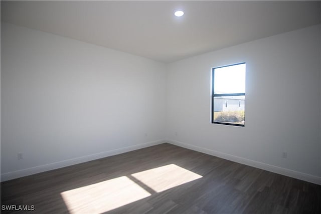 unfurnished room with dark wood-type flooring