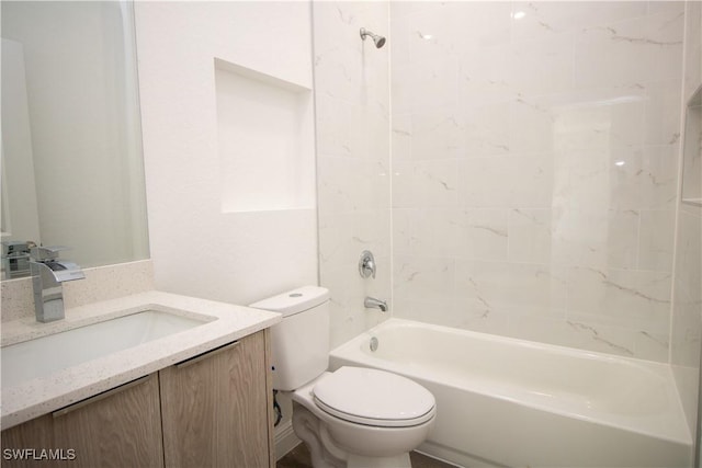 full bathroom featuring toilet, tiled shower / bath, and vanity