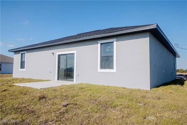 rear view of property featuring a lawn and a patio