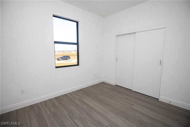 unfurnished bedroom featuring dark wood-type flooring and a closet