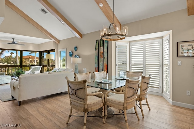 dining area featuring ceiling fan with notable chandelier, light hardwood / wood-style flooring, beam ceiling, and high vaulted ceiling