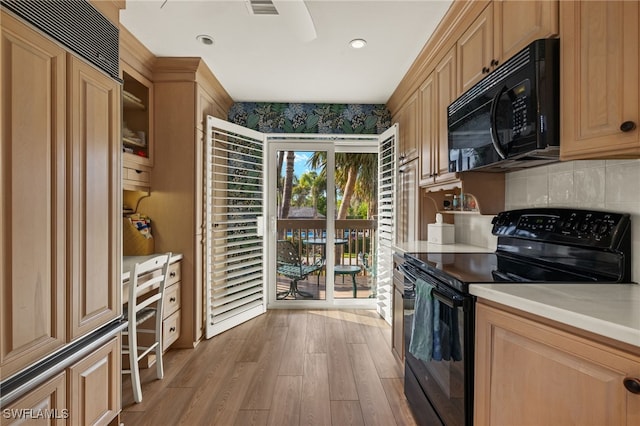 kitchen with light hardwood / wood-style floors and black appliances