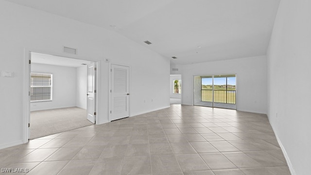 tiled spare room with lofted ceiling