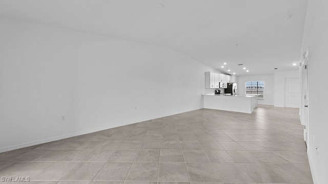 unfurnished living room with light tile patterned floors and lofted ceiling