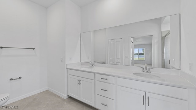 bathroom with tile patterned floors, toilet, vanity, and walk in shower