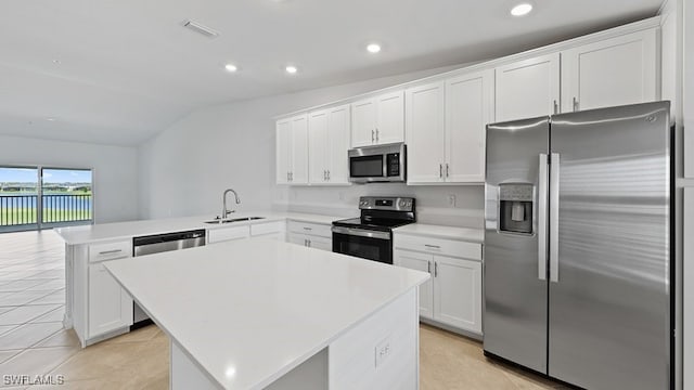 kitchen featuring white cabinetry, stainless steel appliances, lofted ceiling, and kitchen peninsula