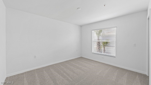 unfurnished room featuring light colored carpet