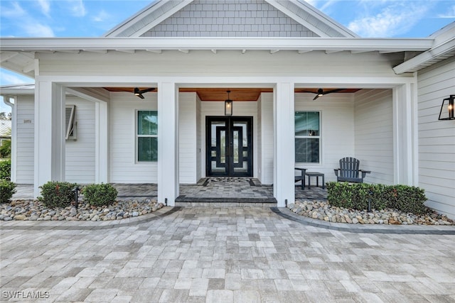 view of exterior entry featuring ceiling fan and a porch