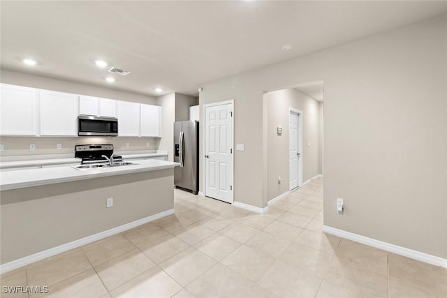 kitchen with light tile patterned floors, stainless steel appliances, white cabinetry, and sink