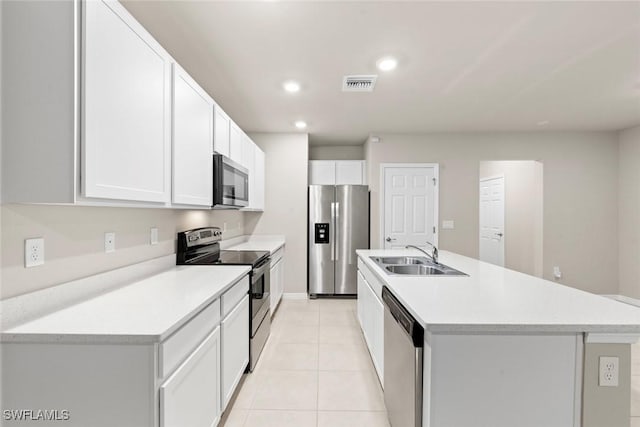 kitchen featuring white cabinetry, stainless steel appliances, sink, a kitchen island with sink, and light tile patterned floors