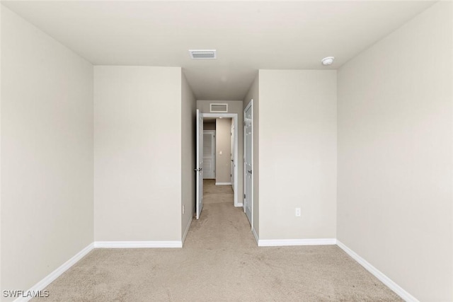 unfurnished room featuring light colored carpet