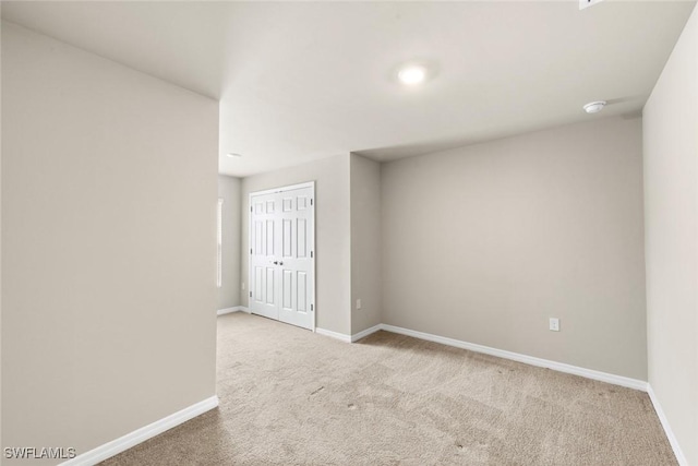 spare room featuring light colored carpet