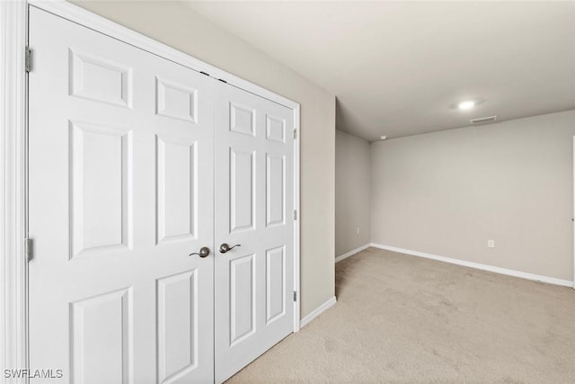 unfurnished bedroom featuring light colored carpet and a closet