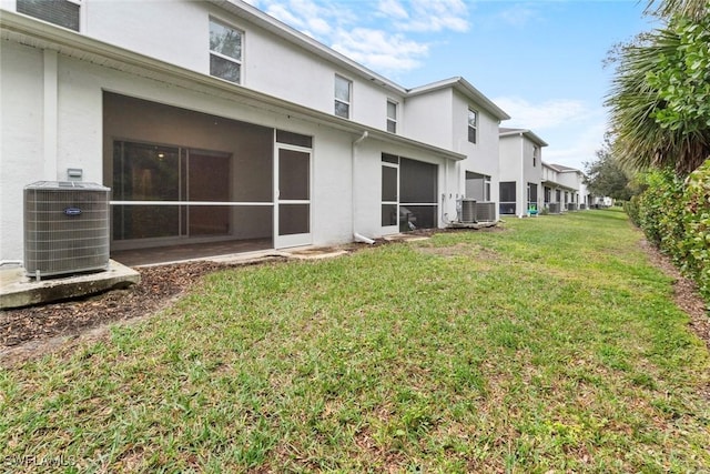 view of yard featuring central AC unit and a sunroom