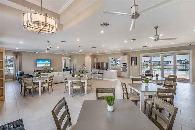 dining space featuring crown molding and ceiling fan with notable chandelier