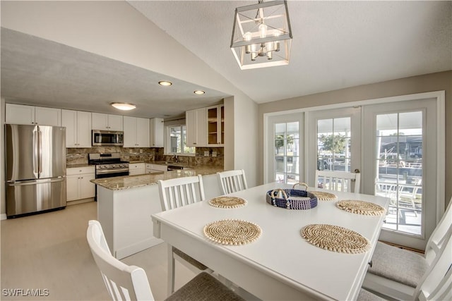 dining area with lofted ceiling and a notable chandelier