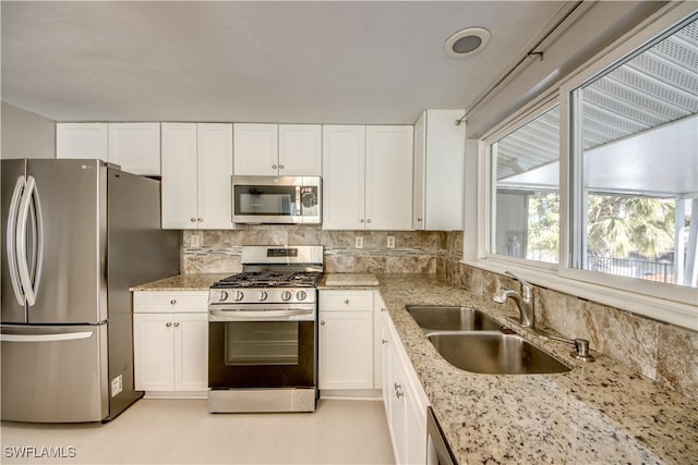 kitchen with appliances with stainless steel finishes, sink, and white cabinets