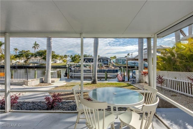 sunroom featuring a water view