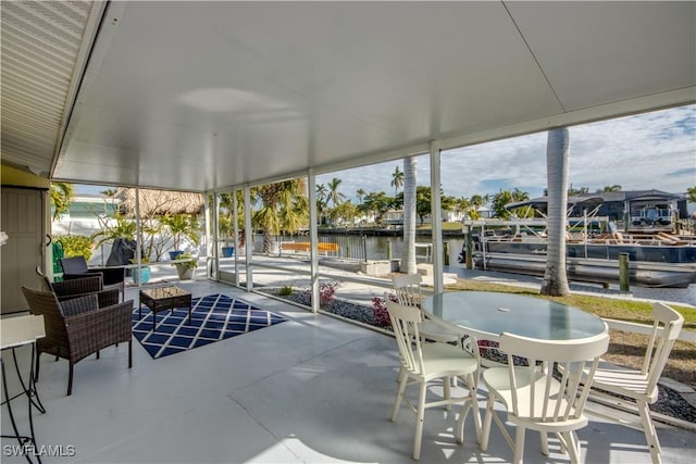 sunroom / solarium with a water view and a healthy amount of sunlight