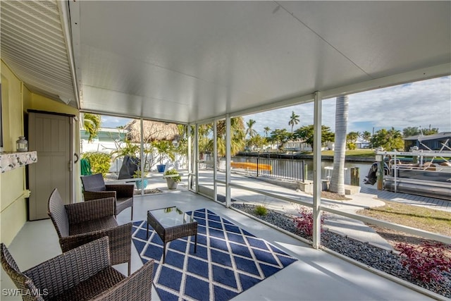 sunroom featuring a water view