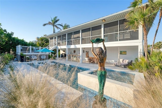 view of swimming pool with a patio and a sunroom