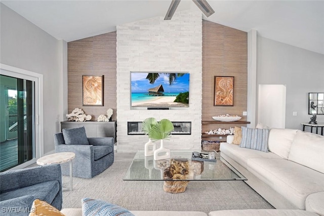 living room featuring lofted ceiling, a fireplace, and wooden walls