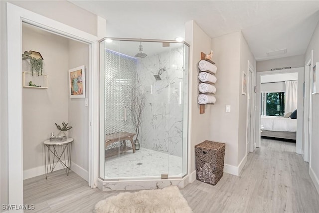 bathroom with hardwood / wood-style flooring and an enclosed shower