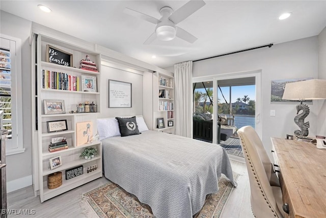 bedroom with a water view, access to outside, light hardwood / wood-style floors, and ceiling fan