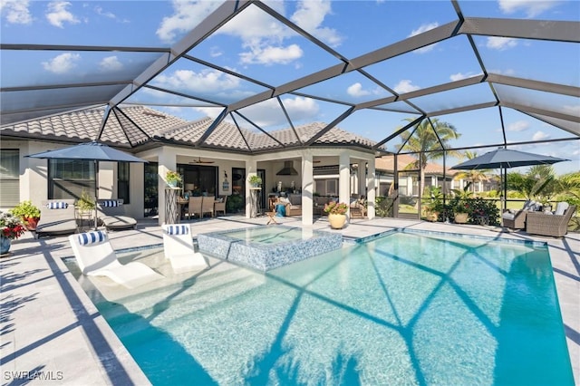 view of swimming pool with ceiling fan, a patio, glass enclosure, and an in ground hot tub