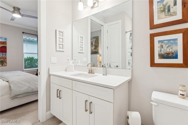 bathroom with ceiling fan, toilet, vanity, and ornamental molding