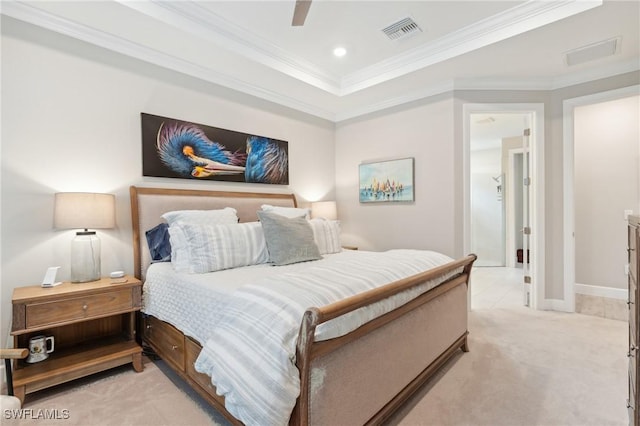 bedroom with ceiling fan, light colored carpet, a tray ceiling, and ornamental molding