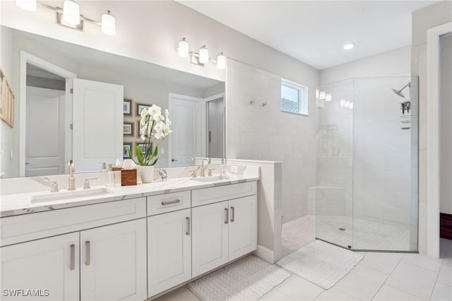 bathroom featuring tile patterned floors, vanity, and a tile shower