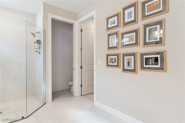 bathroom featuring toilet, tile patterned floors, and a shower with door