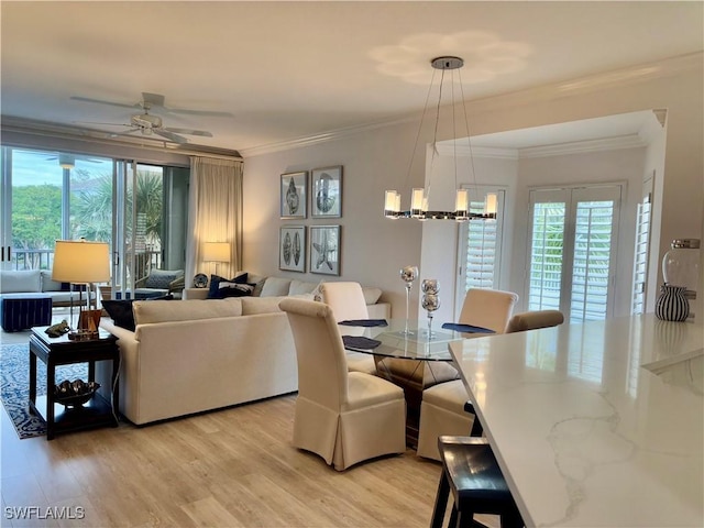 dining room featuring crown molding, ceiling fan with notable chandelier, and light hardwood / wood-style floors