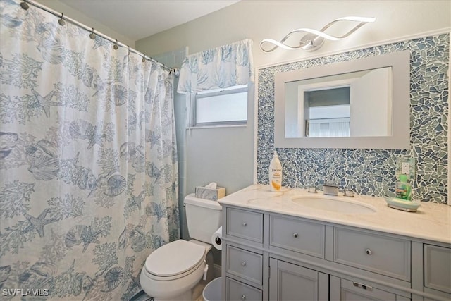 bathroom with toilet, a shower with curtain, backsplash, and vanity