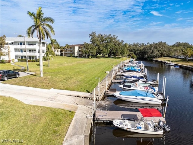 view of dock with a water view and a yard