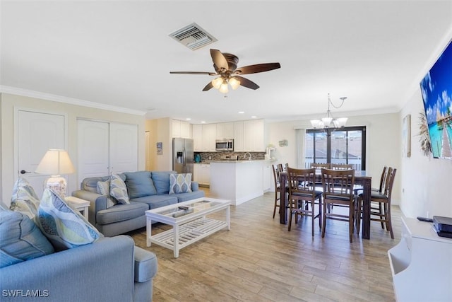 living room featuring ceiling fan with notable chandelier, light hardwood / wood-style flooring, and crown molding