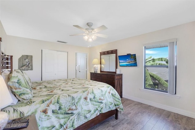 bedroom with ceiling fan, a closet, and hardwood / wood-style floors