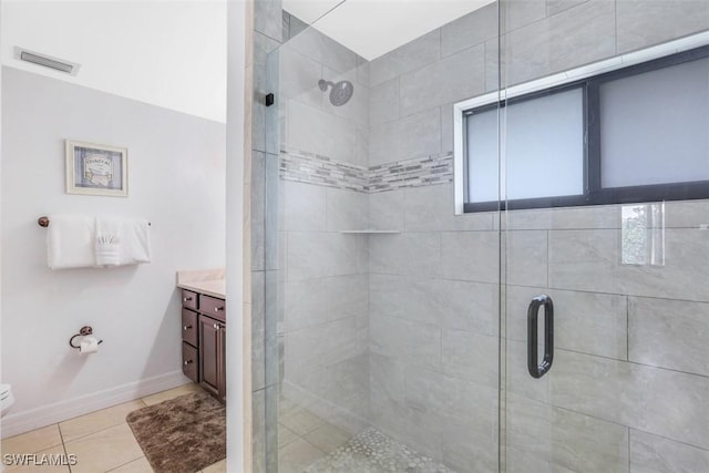 bathroom with a shower with shower door, vanity, tile patterned floors, and toilet