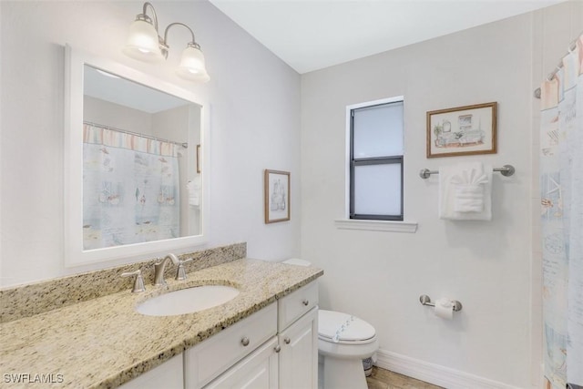 bathroom with toilet, vanity, and a shower with curtain