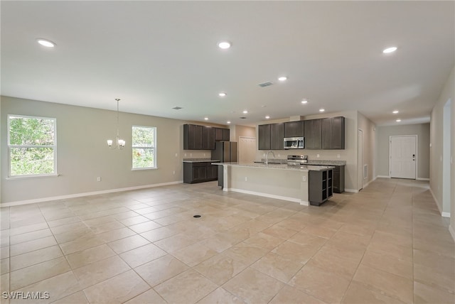 kitchen with stainless steel appliances, plenty of natural light, dark brown cabinetry, and sink